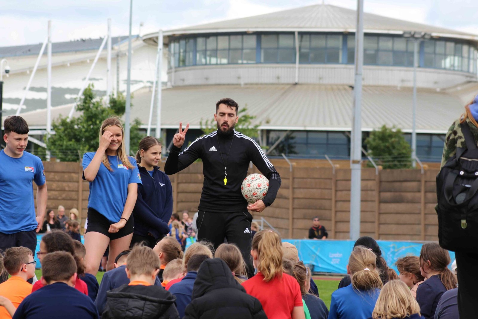 Football freestyler teaching freestyle skills to kids at a football workshop